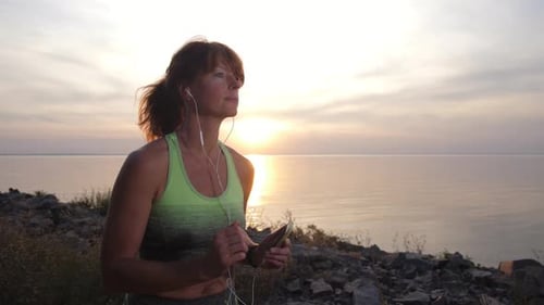 Portrait of Female Jogger in Headphones Outdoors