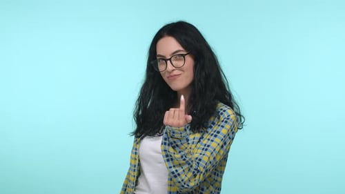 Kokette und selbstbewusste junge Frau winkt dir mit einem Finger und einem lächelnden Köder, näher zu kommen