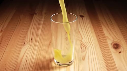 Saft in ein Glas mit Spritzern gegossen
