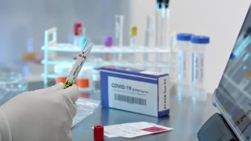 Techniker fügt Covid-19-Tupfer in das Reagenzglas und versiegelt es