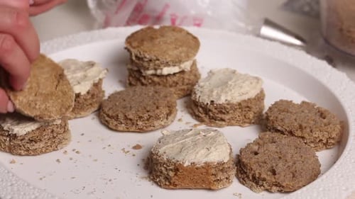 Die Frau macht einen Biskuitkuchen und dekoriert ihn mit Buttercreme.