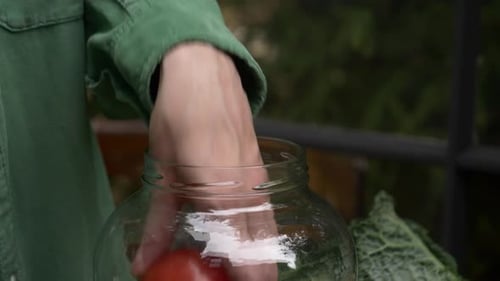 Adding Red Tomatoes to a Glass Canning Jar