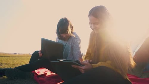 Young Women Using Technology While Camping