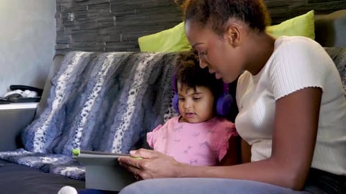Child and Adult Using Tablet Together Indoors