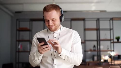 Man with Headphones Using Phone in Office