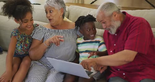 Grandparents and Grandchildren Using Laptop Together Indoors