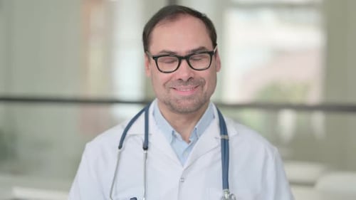 Arzt mittleren Alters zeigt Ja-Zeichen mit dem Finger