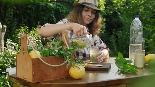 Woman Pouring Lemonade with Mint in Sunny Garden