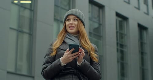 Caucasian Young Stylish Redhead Woman Talking on Cellphone in the Morning at Street. Beautiful Happy