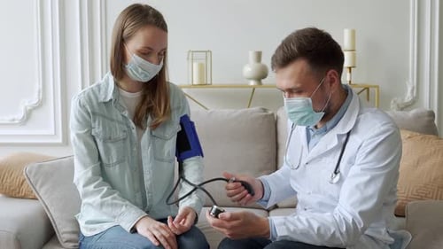 Doctor Taking Blood Pressure of Patient in Office