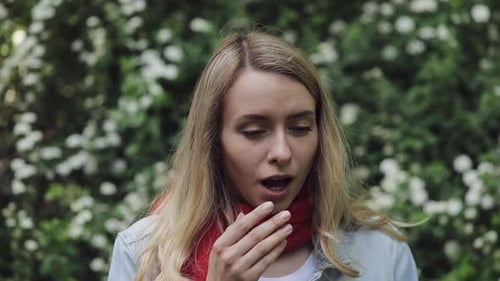 Woman Coughing and Rubbing Eyes in Spring Garden
