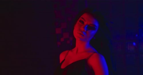 Glamorous Young Woman Posing in Red and Blue Light