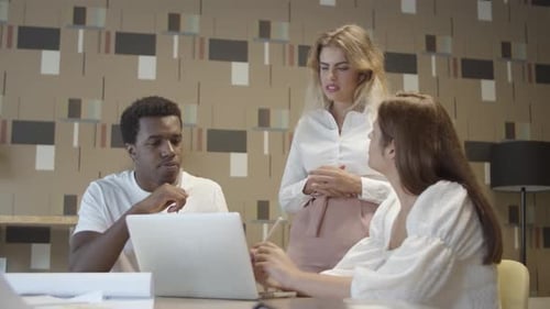 Team Collaborates on Laptop in Modern Office
