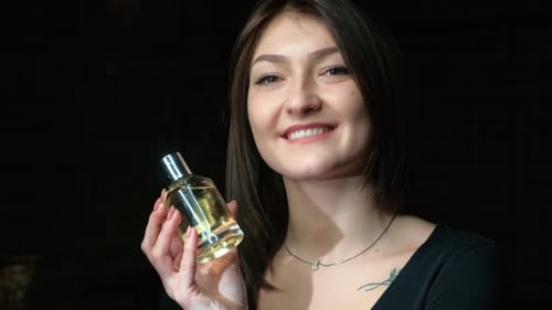 Woman Smiling, Holding Perfume Bottle