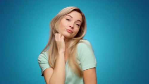 Attractive Blond Woman Posing Against Blue Backdrop