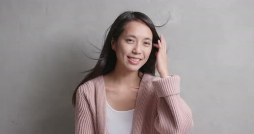 Asian woman smile to camera over gray background