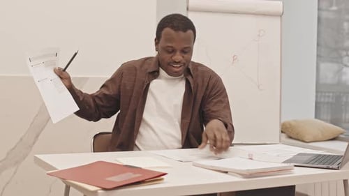 Friendly Man Presents Virtual Lesson at Desk