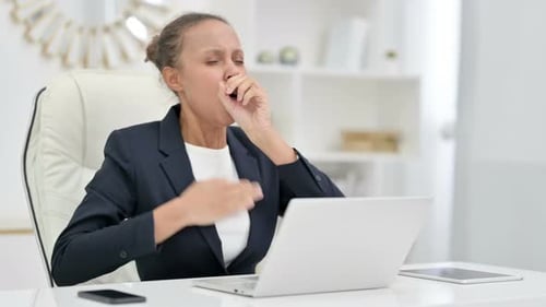 Sick African Businesswoman with Laptop Coughing in Office