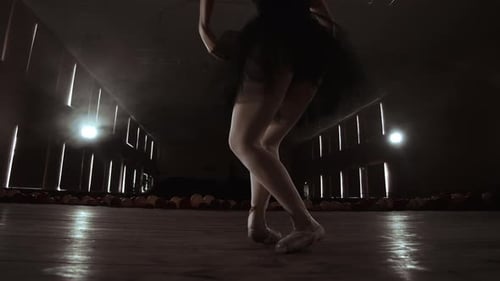 Ballerina Dancing En Pointe on Dark Stage