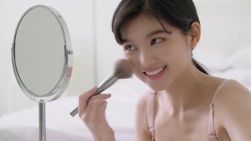 Beauty young asian woman happy and smile with face looking mirror applying makeup with brusher.