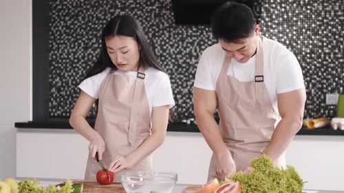 Couple Prepares Salad Together in a Modern Kitchen