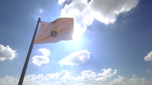 Waving Flag with Coat of Arms Against Bright Blue Sky