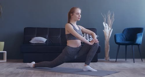 Young Woman Stretching on Yoga Mat Indoors