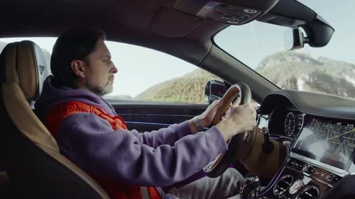 Der Fahrer, der das Auto fährt, schaut auf seine Armbanduhr