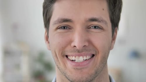 Gesicht Nahaufnahme eines lächelnden gutaussehenden jungen Mannes