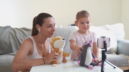 Mother with Child Streaming Online Video of Unboxing Clothes. Influencer Occupation, Mommy Blog