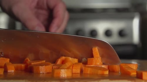 Chopping Fresh Carrots in Kitchen