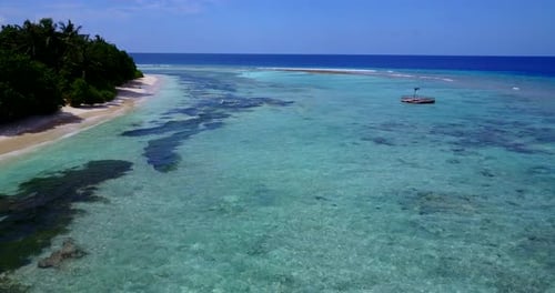 Daytime drone tourism shot of a sandy white paradise beach and blue sea background in colourful