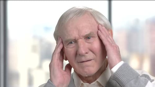 Senior Man Massaging Temples to Relieve Headache
