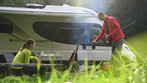 Couple Camping, Cooking Food by Campfire