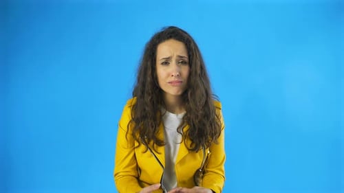Disappointed and a Very Sad Young Woman Almost Crying in Studio with Blue Background.