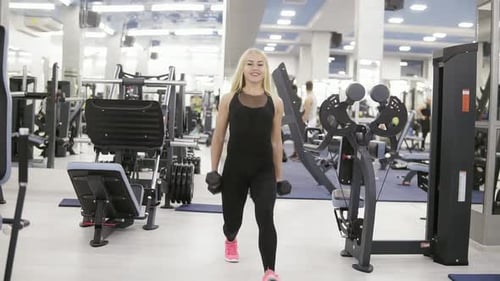 Woman Doing Lunges with Dumbbells at Gym