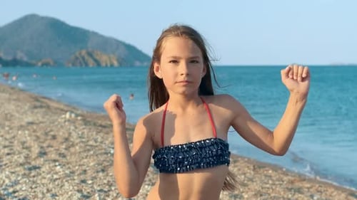 Young Girl Dancing Merry Dance on Sea Beach. Happy Child Having Fun on Beach