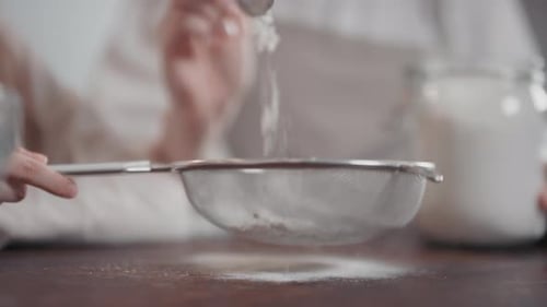 Sifting White Flour onto Wooden Surface