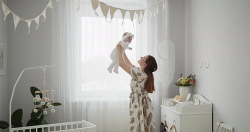 Mother Raises Baby in Bright Nursery Room