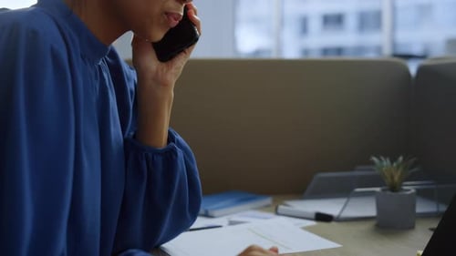 Young Woman Talking on Phone Using Laptop in Office