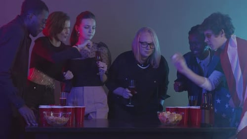 Cheerful Friends Playing Beer Pong at Party