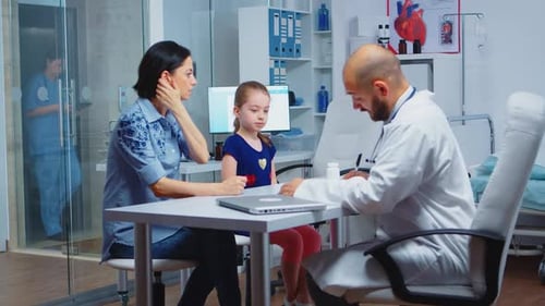 Doctor Consults with Child and Adult in Hospital Room