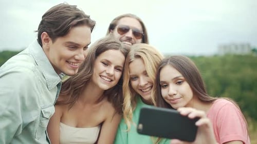 Smiling Friends Taking Selfie Together Outdoors