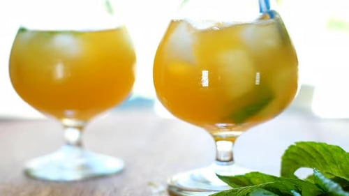 Faire tourbillonner une boisson kombucha infusée à la menthe avec de la paille bleue rayée ; statique