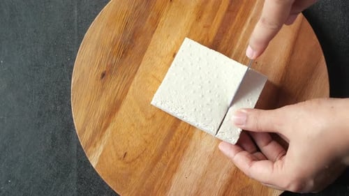 Top View of Hands Cutting Tofu with Knife