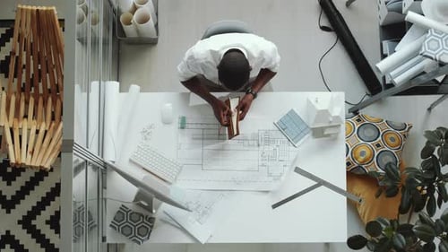 Architect Working on Blueprints at Desk, Overhead Shot