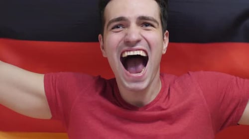 Enthusiastic Man Cheerfully Celebrates with National Flag