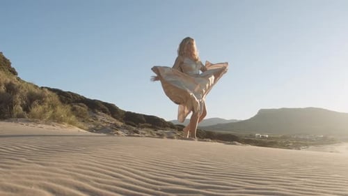 Blond Woman In Gold Dress Dancing On Beach Blond Woman In Gold Dress Dancing On Beach