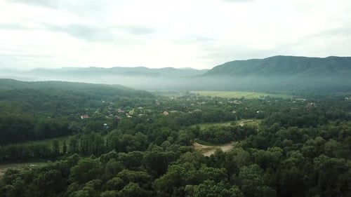 Aerial View of Sunset with Fog Above Forest and Mountains. Morning Foggy Smoke in Magic Rays Light