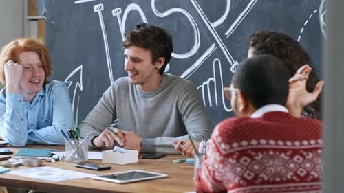 Young Creative Coworkers Smiling and Chatting in Office